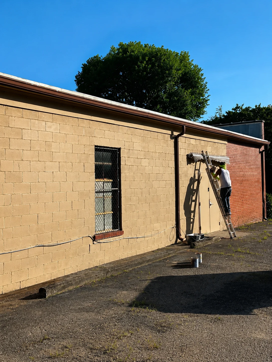 Exterior painting work in progress by Durant Repairs & Renovations with worker near the doorway